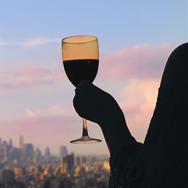 Person holding a glass of wine with view of the city - therapist for substance use in Connecticut - Fairfield, Norwalk, Darien, Bridgeport, Westport, Southport