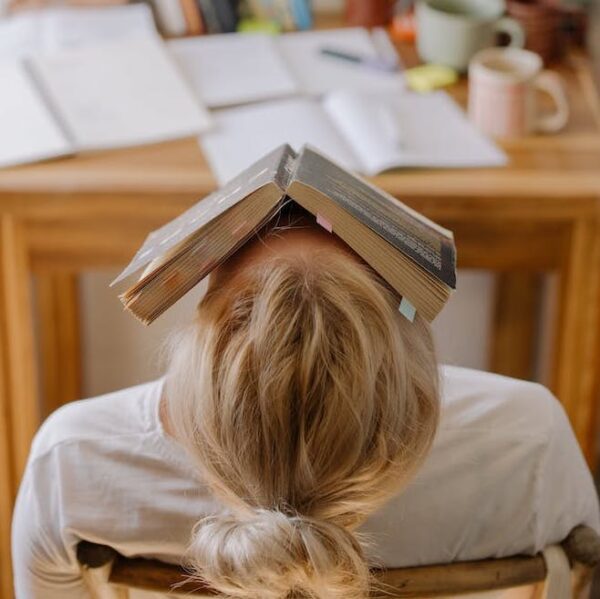overwhelmed teen with book on their head