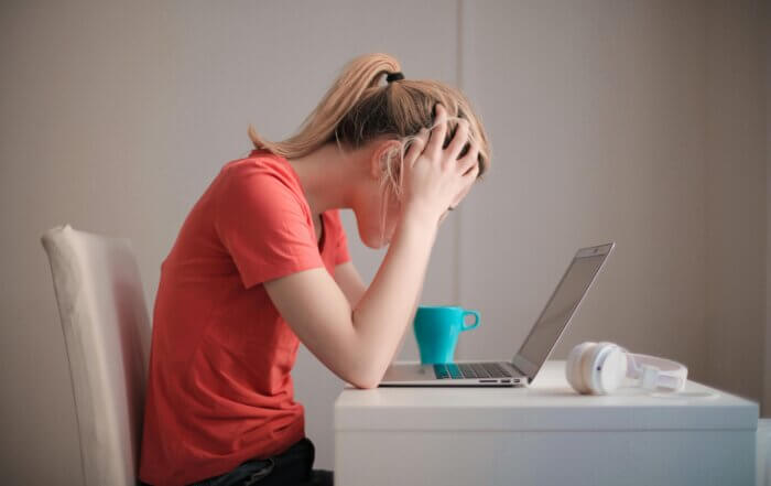 Woman experiencing a panic attack in front of her computer