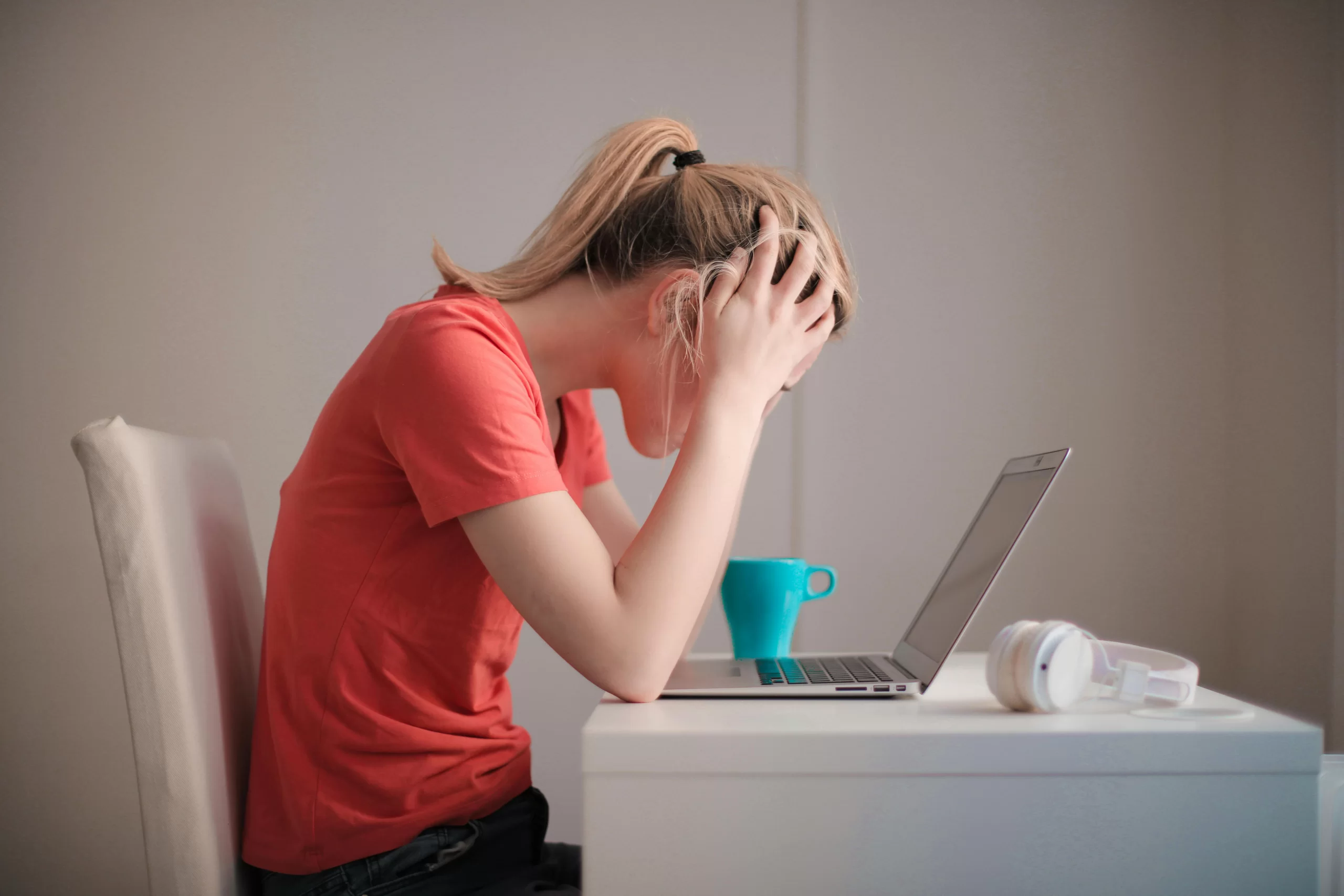 Woman experiencing a panic attack in front of her computer