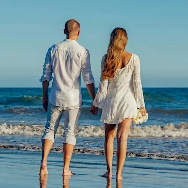 a couple on the beach holding hands