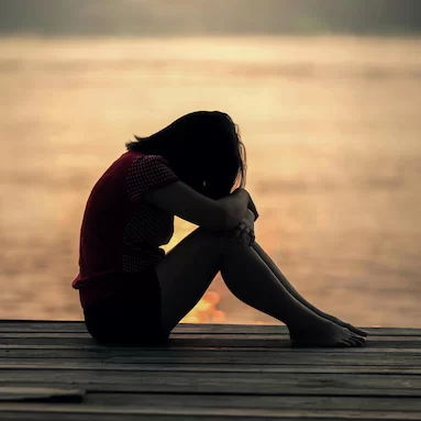 a person in the sand , sad at the beach